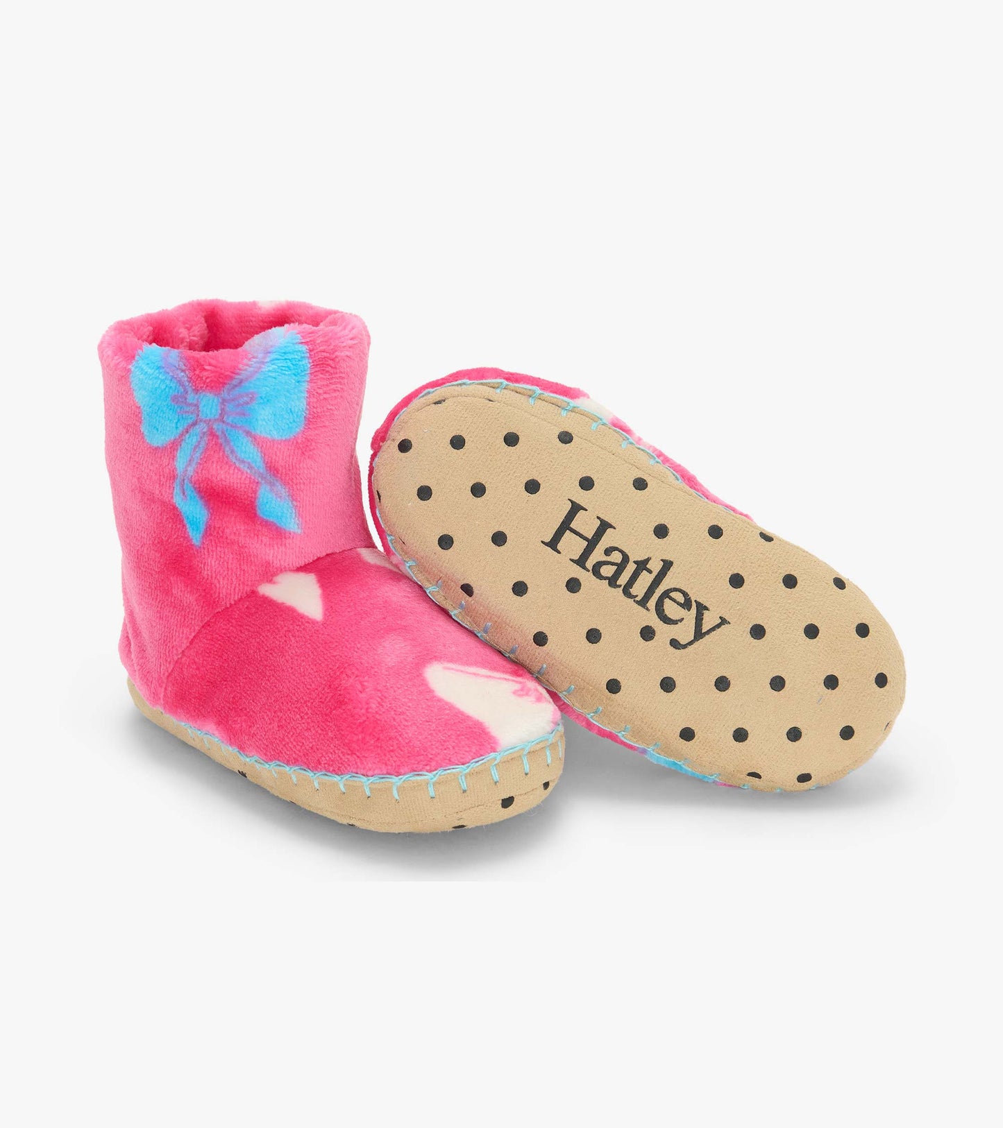 Pink slipper boots with blue bow print shown with tan polka dot sole and visible Hatley logo