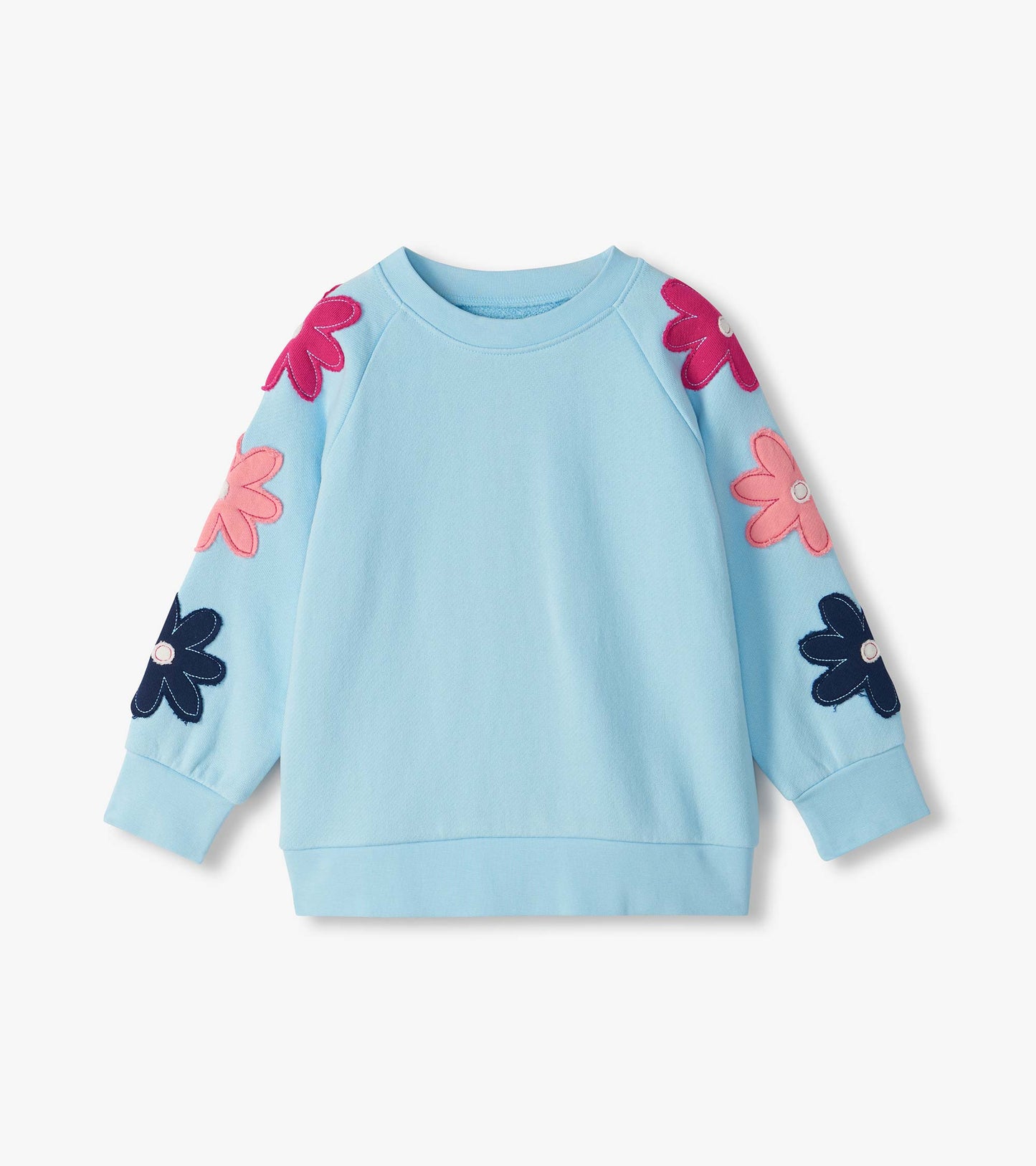 Light blue slouchy pullover with raglan sleeves and oversized pink and navy flower appliqués on the arms