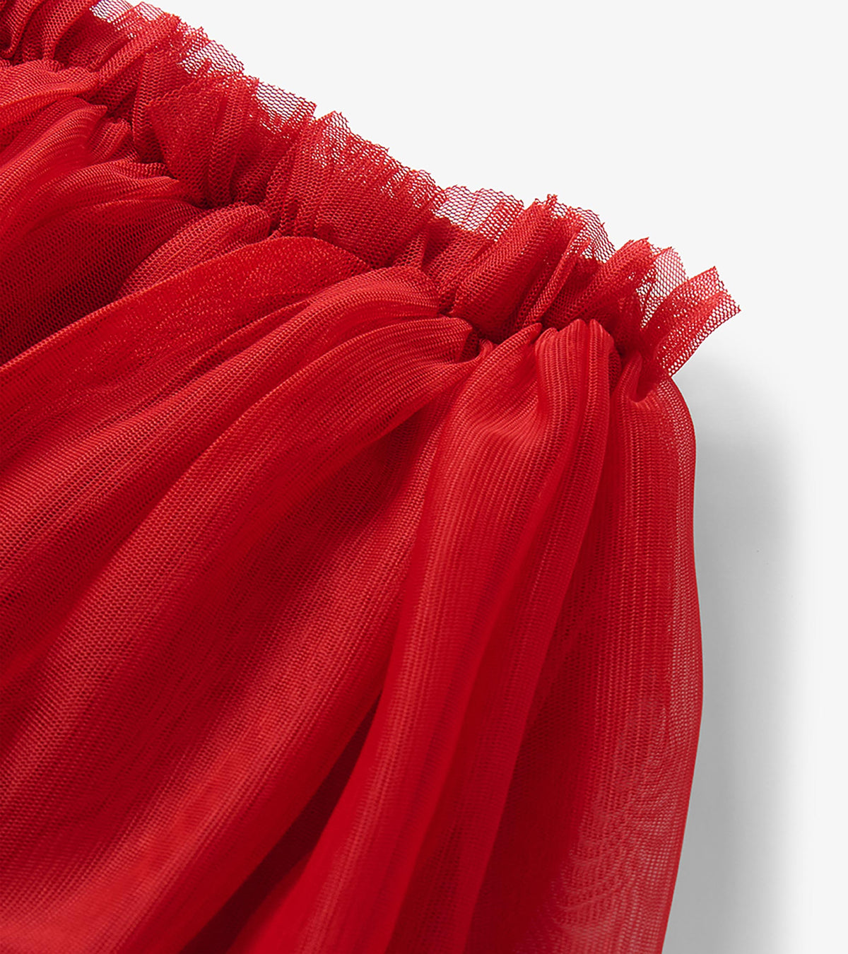 Close-up of red tutu skirt waistband and gathered sheer overlay detail
