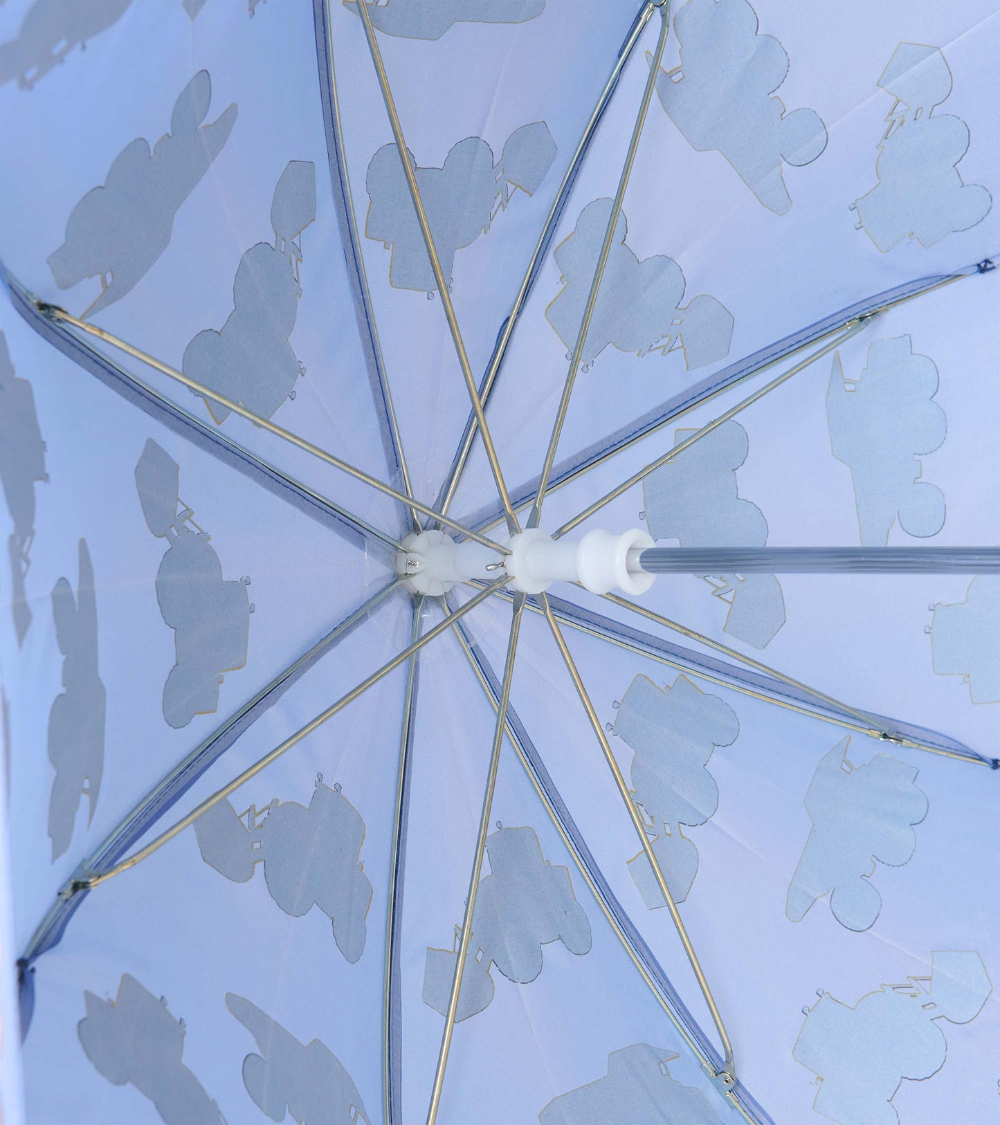 Underside of blue umbrella showing metal ribs and pale construction truck silhouettes
