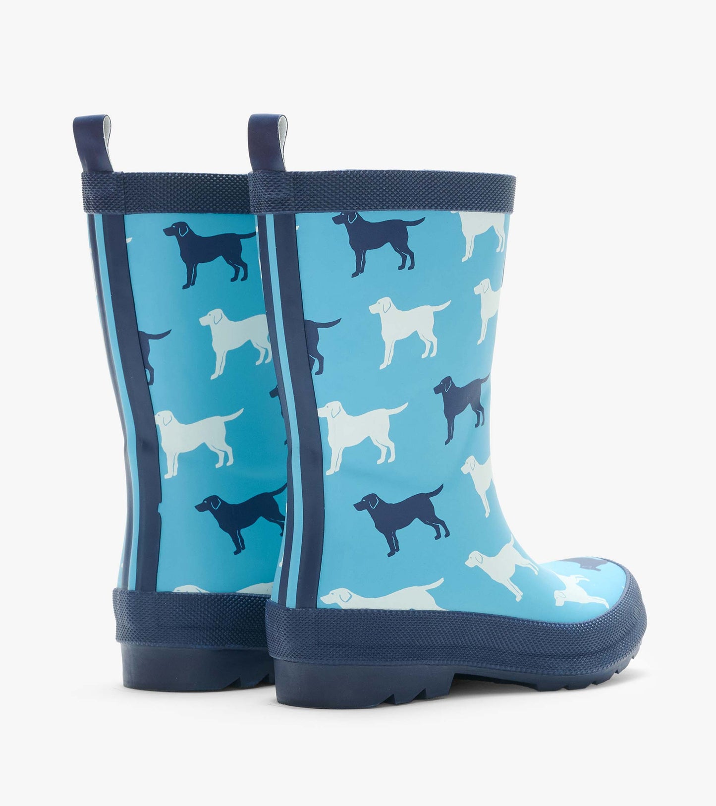 Rear angled view of blue kids rain boots with white and navy dog silhouettes and pull tabs