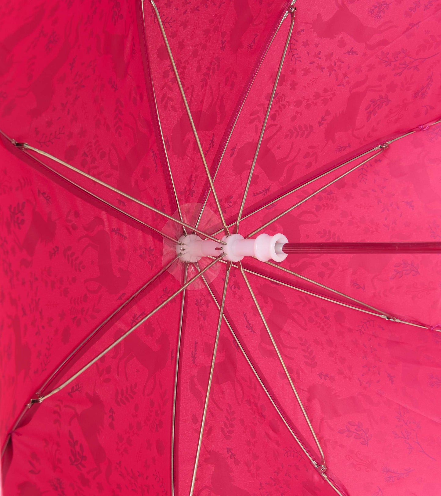 Interior view of pink umbrella showing metal ribs and reverse side of the unicorn forest print
