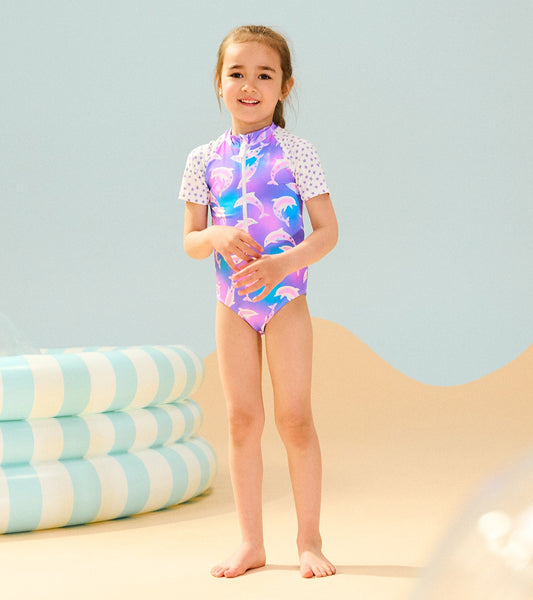 Colorful one-piece rashguard featuring dolphins and star-patterned sleeves, ideal for beach or pool activities.