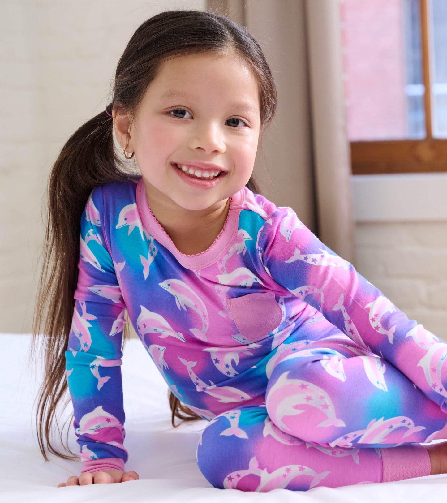 Bamboo pyjama set featuring a colorful dolphin pattern in pink and blue, designed for girls aged 2 to 12.