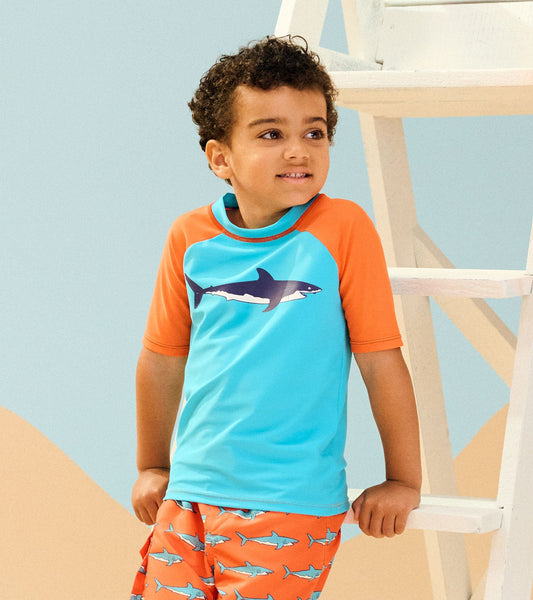 Short sleeve rashguard in turquoise and orange with shark graphic, perfect for beach or pool activities.