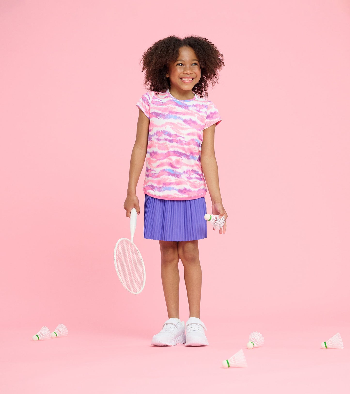 Girls' short-sleeve t-shirt featuring a pink and purple ombre pattern, paired with a pleated purple skirt.