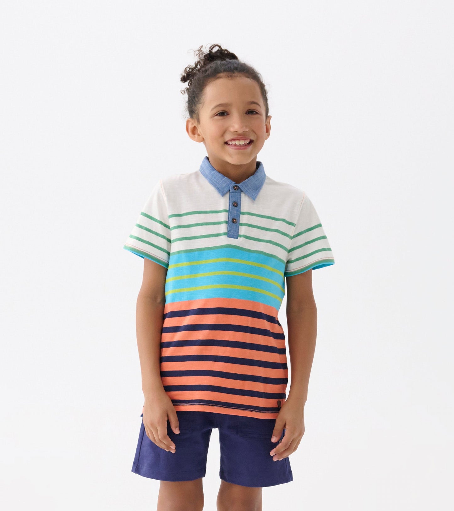 Striped polo tee in green, blue, orange, and navy, featuring a denim collar and short sleeves, worn by a smiling child.