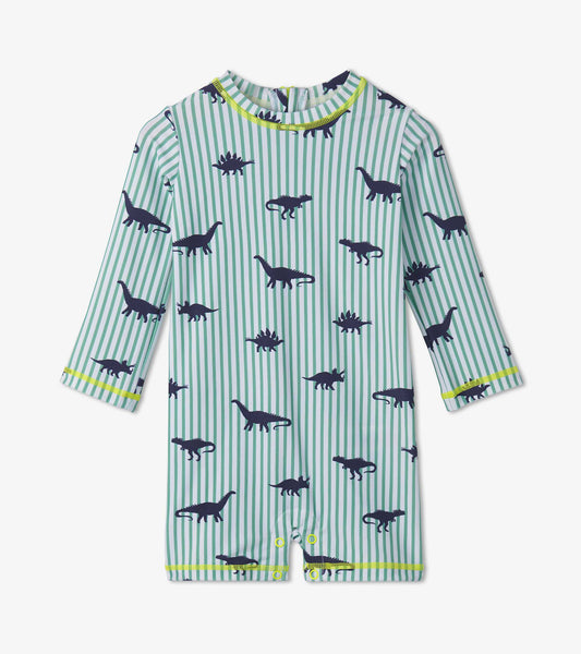 Light green one-piece rashguard with navy dinosaur prints and stripes, featuring long sleeves and snap closures at the botto…