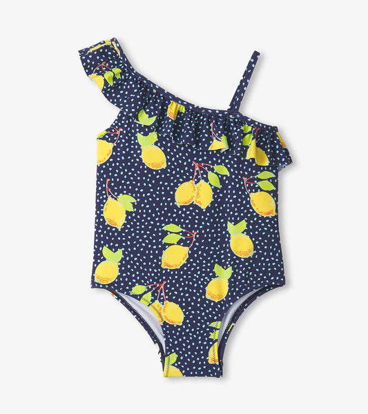 Navy swimsuit with yellow lemon pattern and ruffle trim, featuring one shoulder strap and polka dot accents.