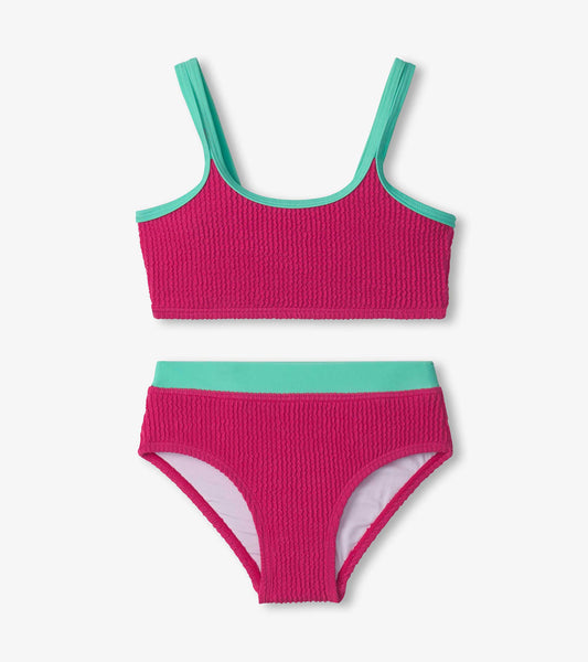 Fuchsia purple bikini set with textured fabric, featuring a crop top and matching bottoms with turquoise accents.