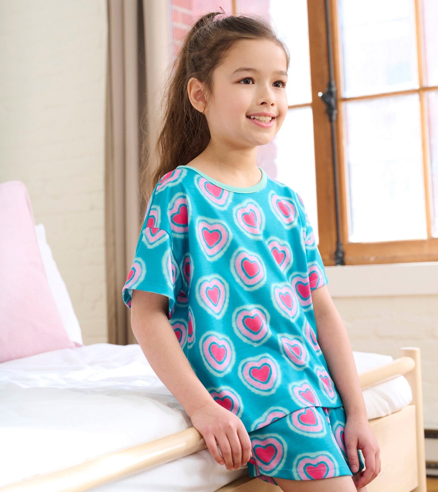 Turquoise pajama set featuring a heart pattern, includes a short-sleeve top and matching shorts.