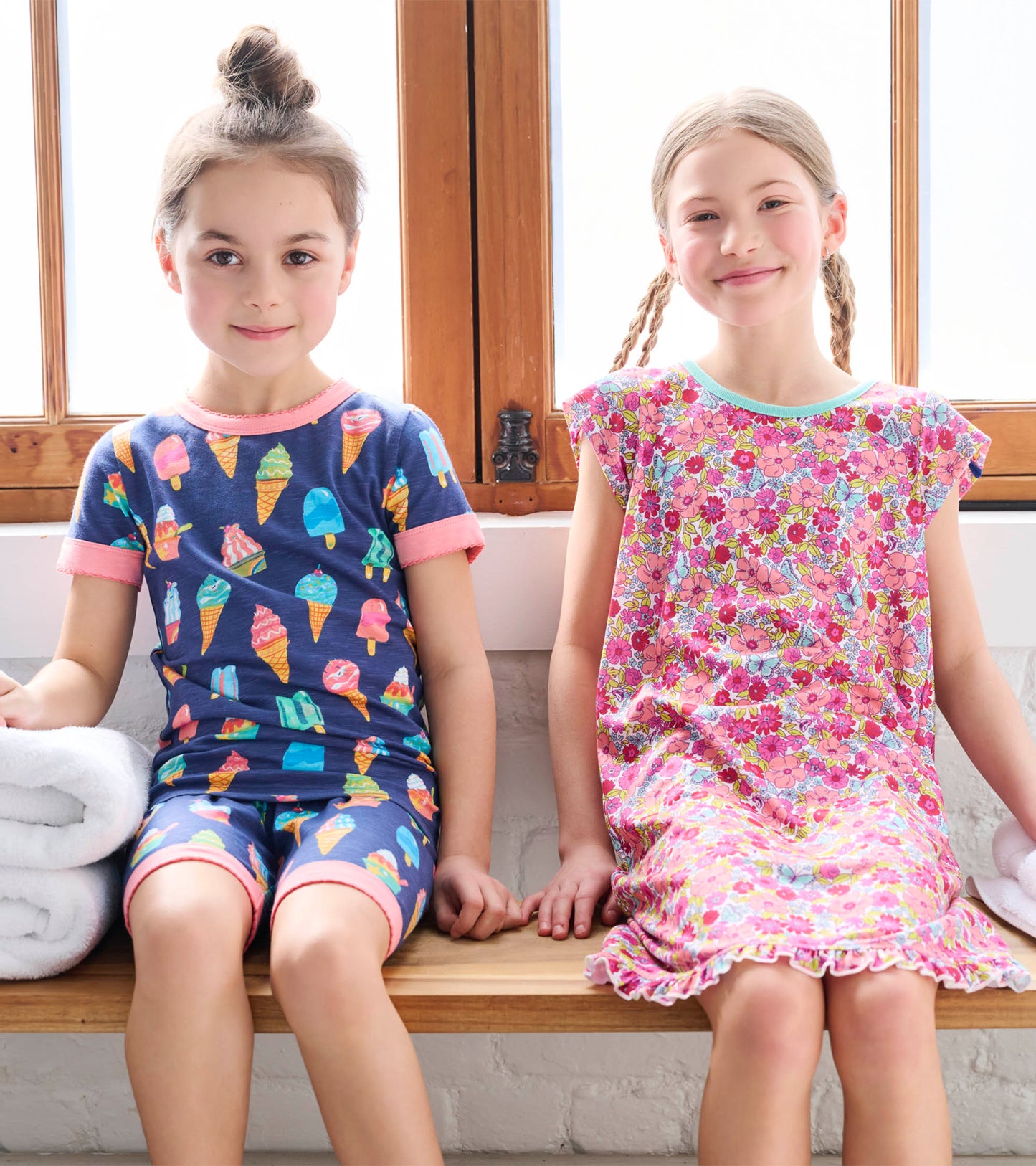 Short pyjama set featuring a blue top with ice cream prints and a pink floral dress, perfect for girls.