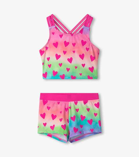 Two-piece short swimsuit featuring a colorful gradient with pink hearts, adjustable straps, and a comfortable fit.