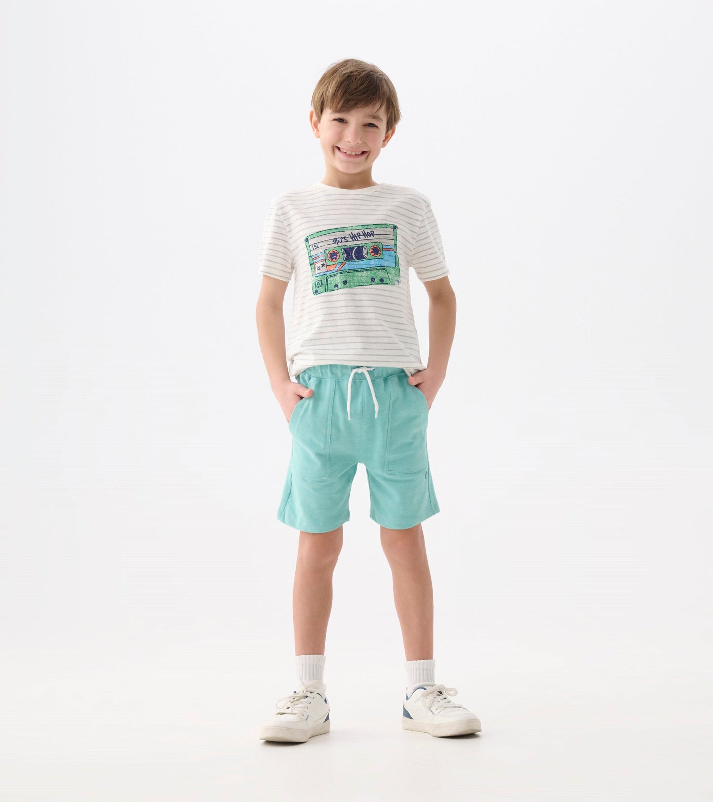 Light blue relaxed shorts with an elastic waistband, paired with a striped t-shirt, worn by a smiling boy.