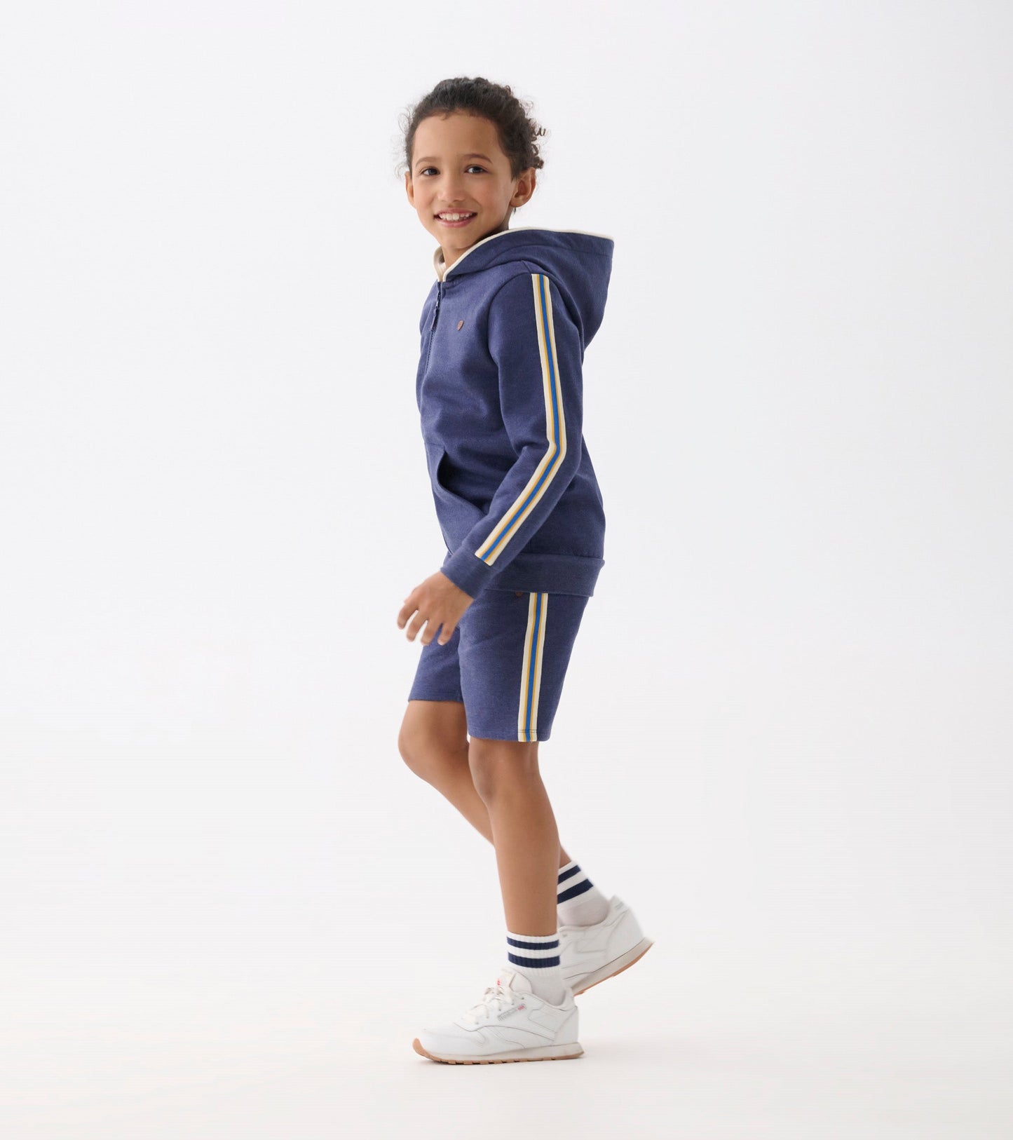 Patriot blue zip-up hoodie with yellow and white stripes, worn by a smiling boy, paired with matching shorts.