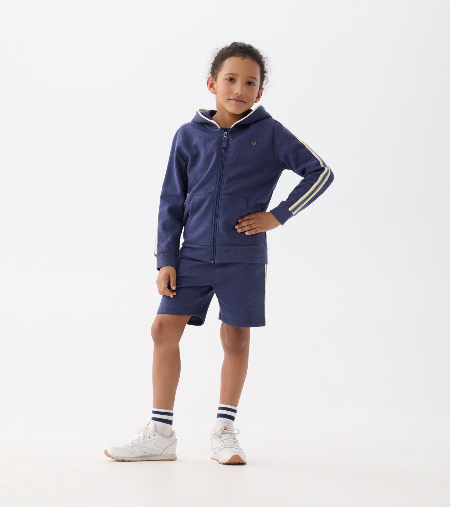 Patriot blue zip-up hoodie with a hood, front pockets, and striped sleeves, worn by a child standing confidently.