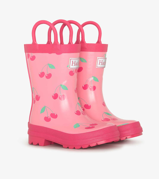 Pink rubber wellies featuring a cherry pattern and dual handles for easy wear. Ideal for rainy days.