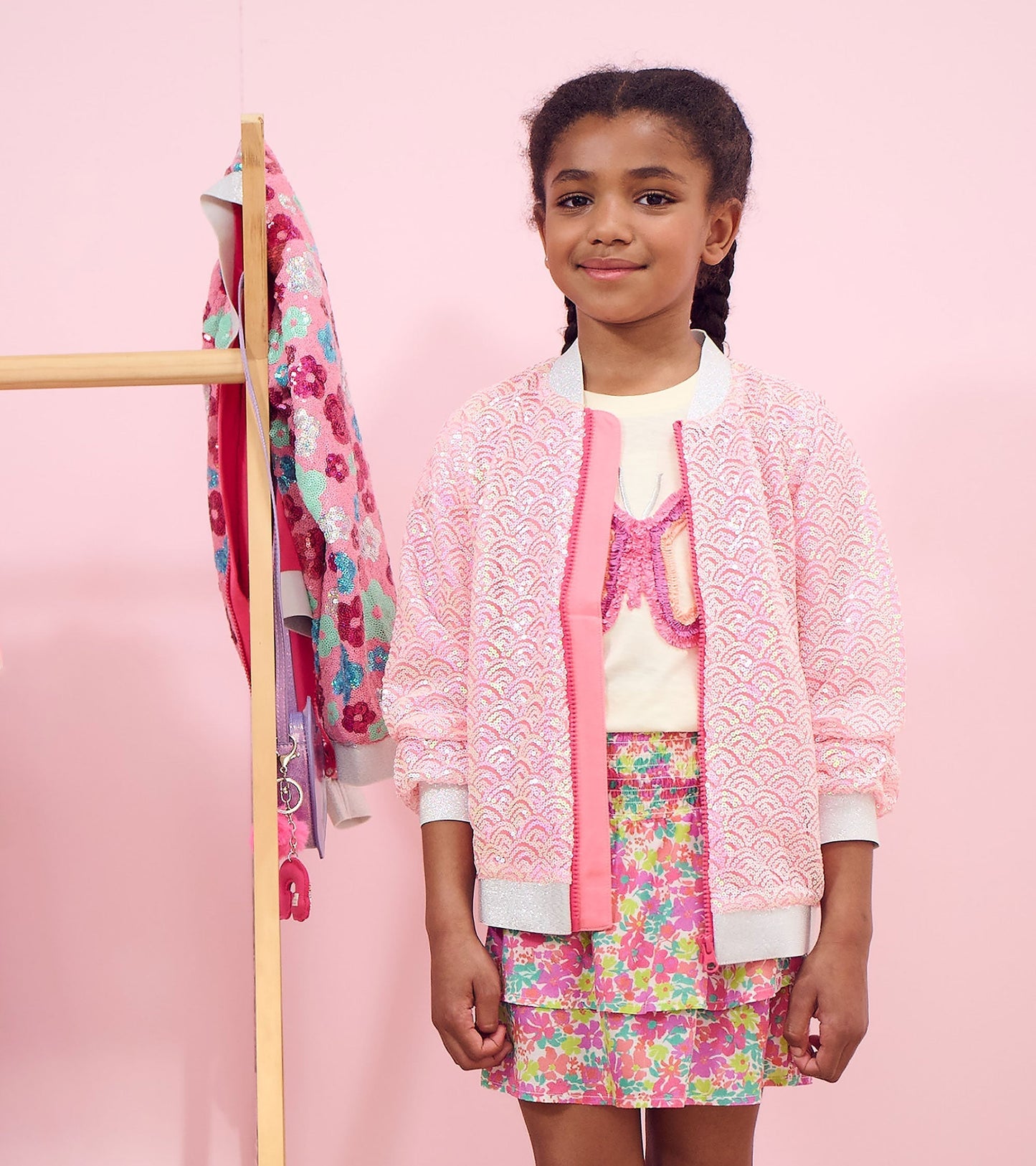 Pink sequined bomber jacket with mermaid scale pattern, featuring a ribbed collar and cuffs, worn by a girl.