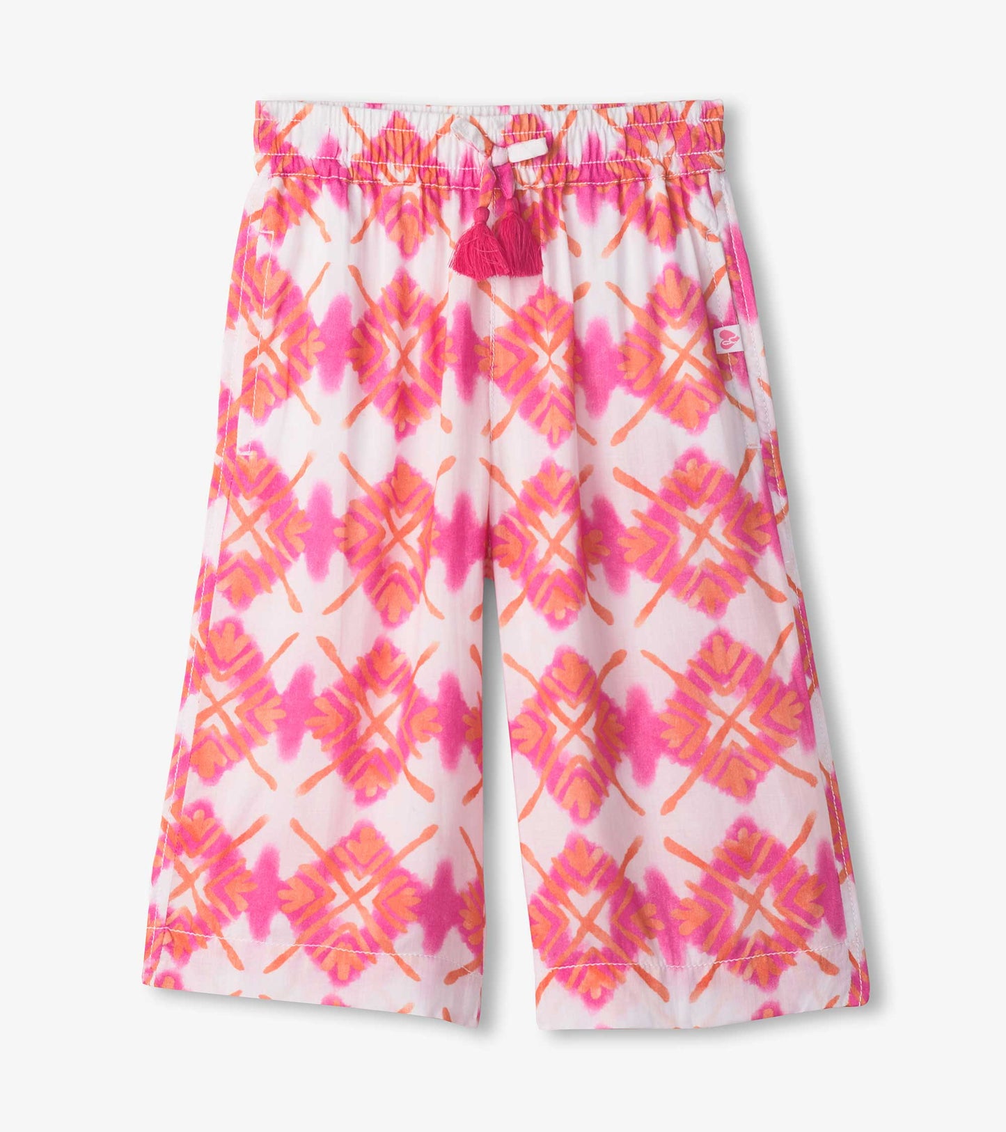 Cropped culottes featuring a vibrant pink and orange sunburst pattern with a drawstring waist and tassel detail.