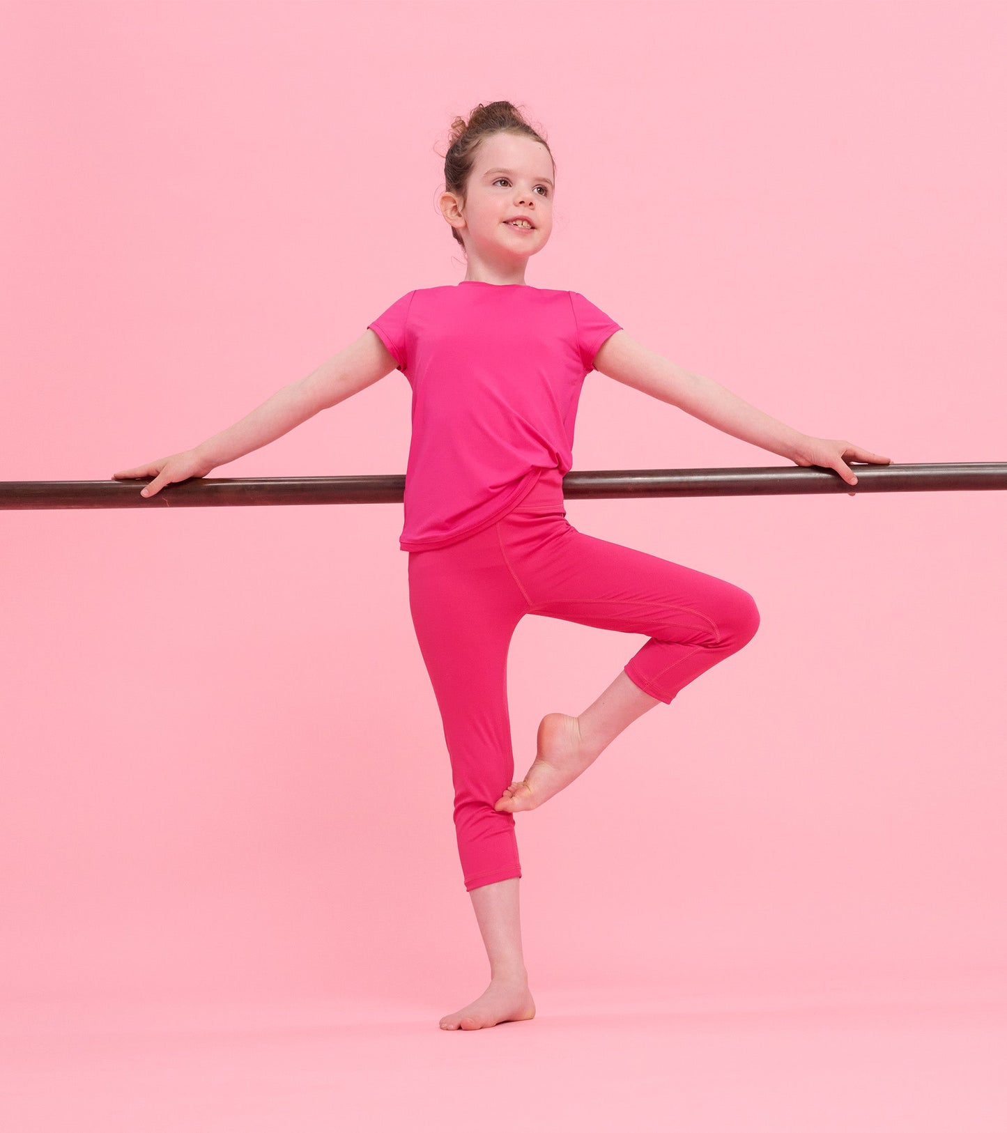 Bright pink short-sleeve T-shirt with mesh trim, styled for active wear, paired with matching leggings.