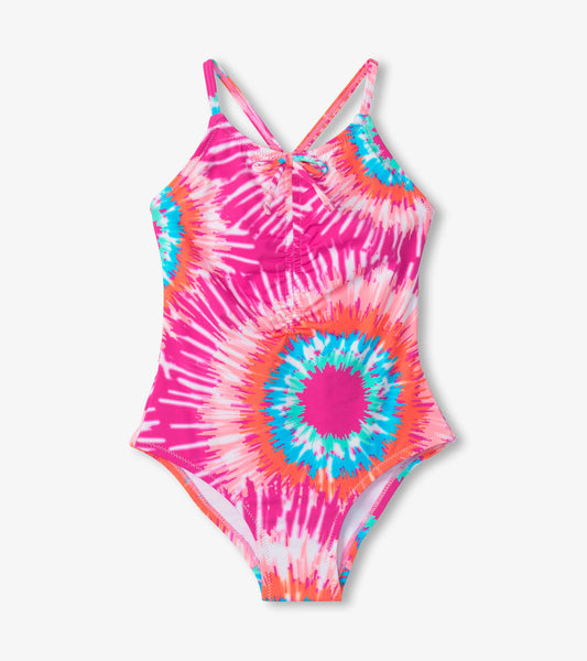 Pink and multicolor tie-dye swimsuit with ruched front and crisscross straps, ideal for summer swimming.