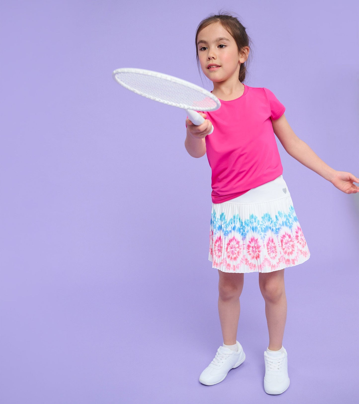 White sporty skort with a colorful sunburst pattern, paired with a pink top, suitable for active play.