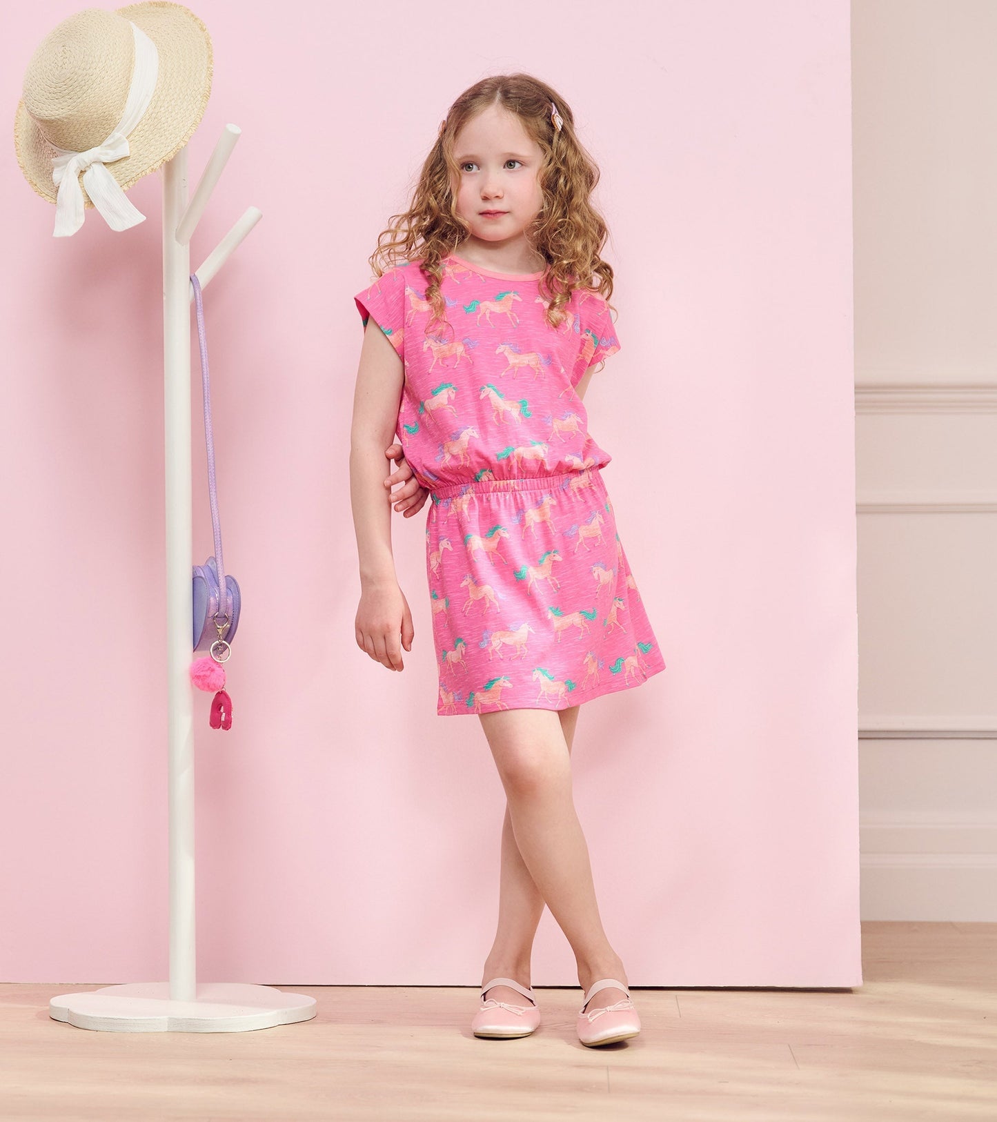 Pink relaxed dress featuring a horse print, short sleeves, and an elastic waistband, suitable for casual wear.