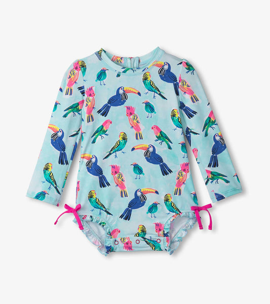 Light blue long-sleeve rashguard swimsuit featuring colorful tropical birds and pink tie details at the legs.