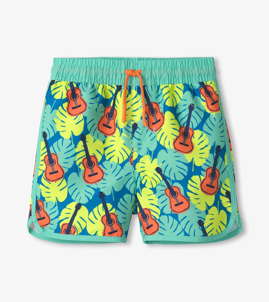 Boys' swim shorts featuring a vibrant tropical pattern with guitars and leaves in blue, green, and orange colors.