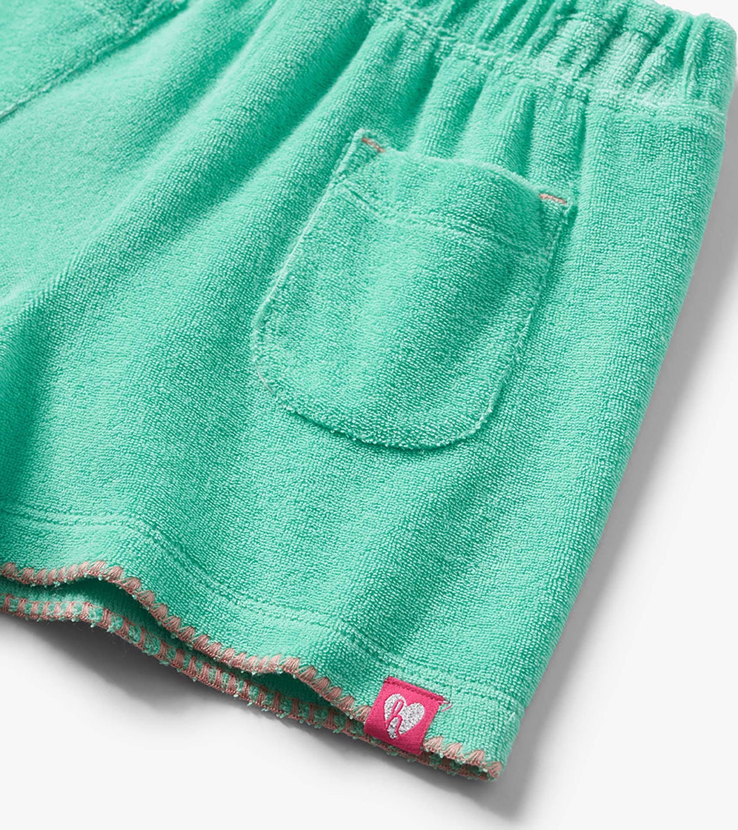Mint green terry cloth toddler shorts with elastic waist, back pocket, and pink stitched hem detail