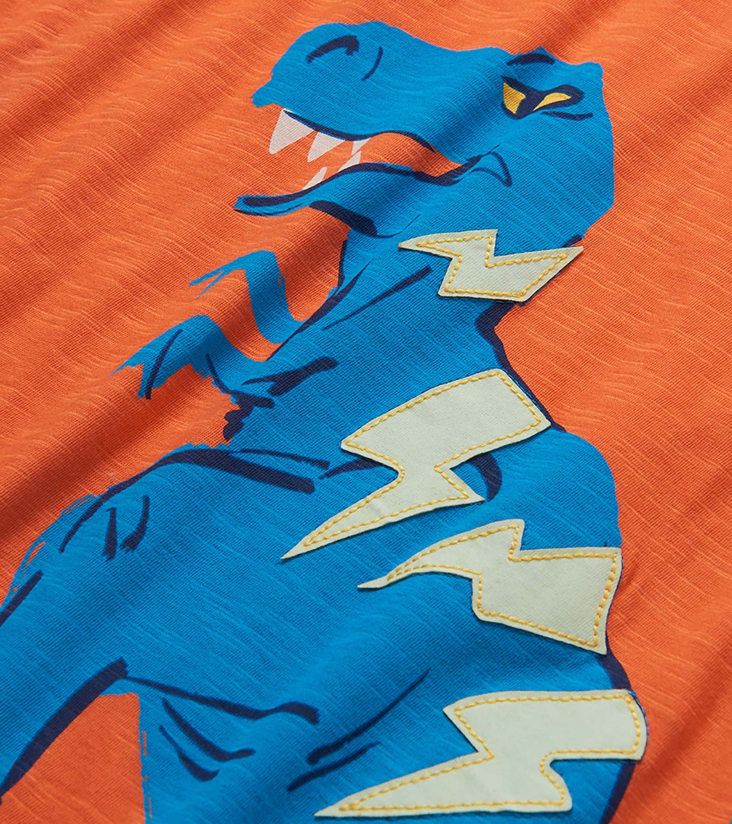 Blue boys T-shirt with orange background and large dinosaur graphic with lightning bolts, front view