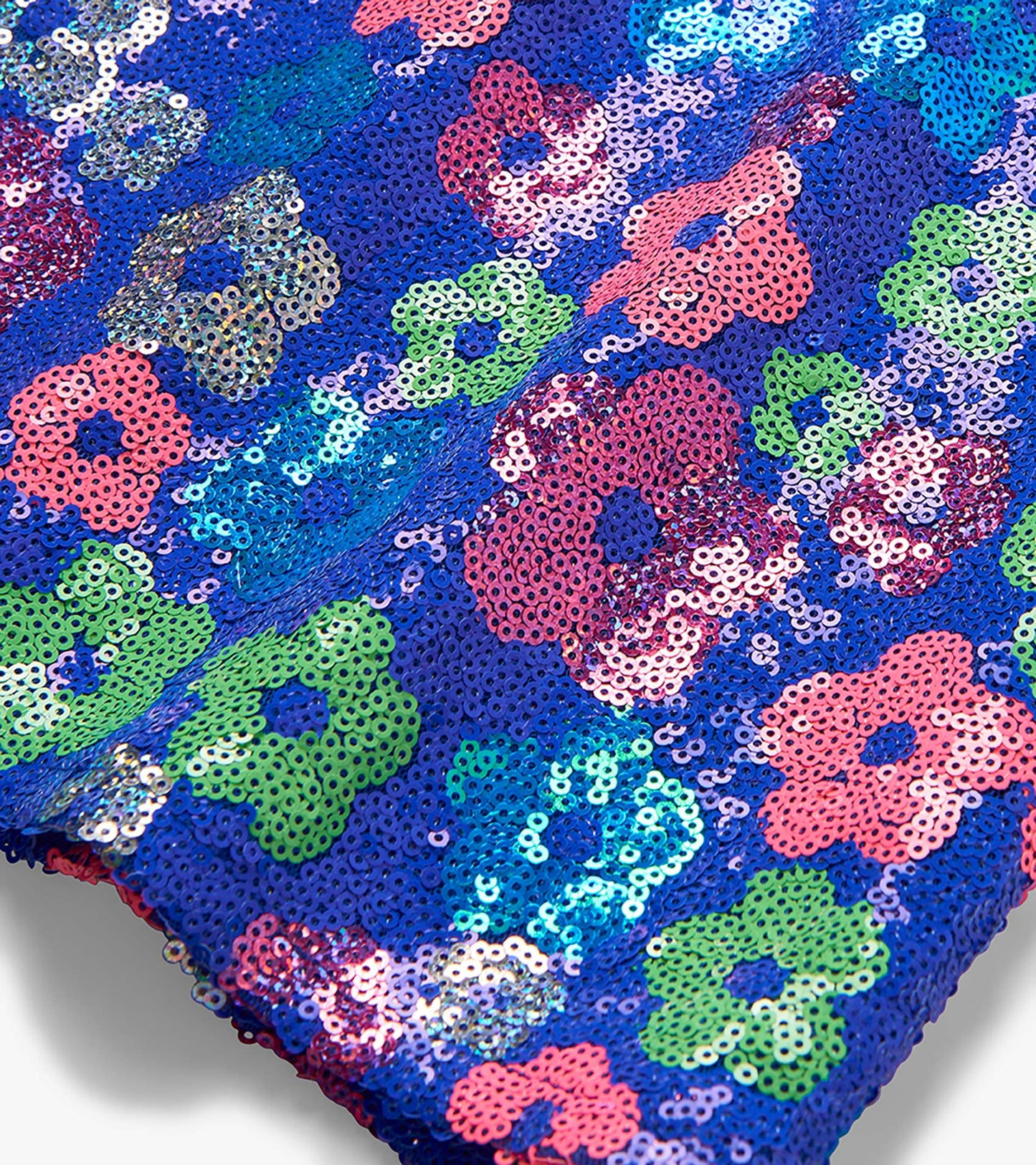 Close-up of a blue sequin top with multicolored floral pattern and scalloped hem