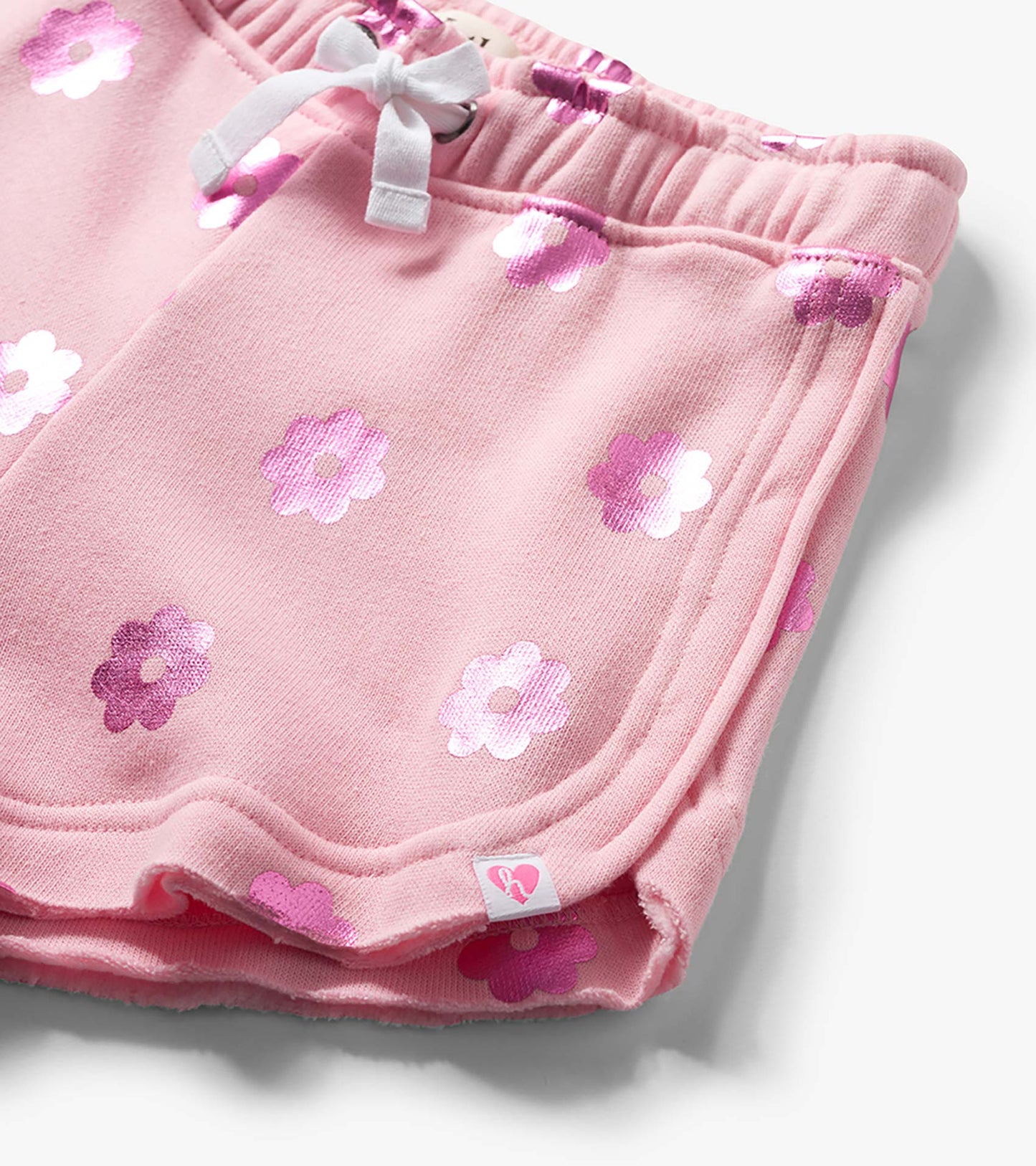 Pink girls pull-on shorts with white drawstring and pink floral print, close-up view