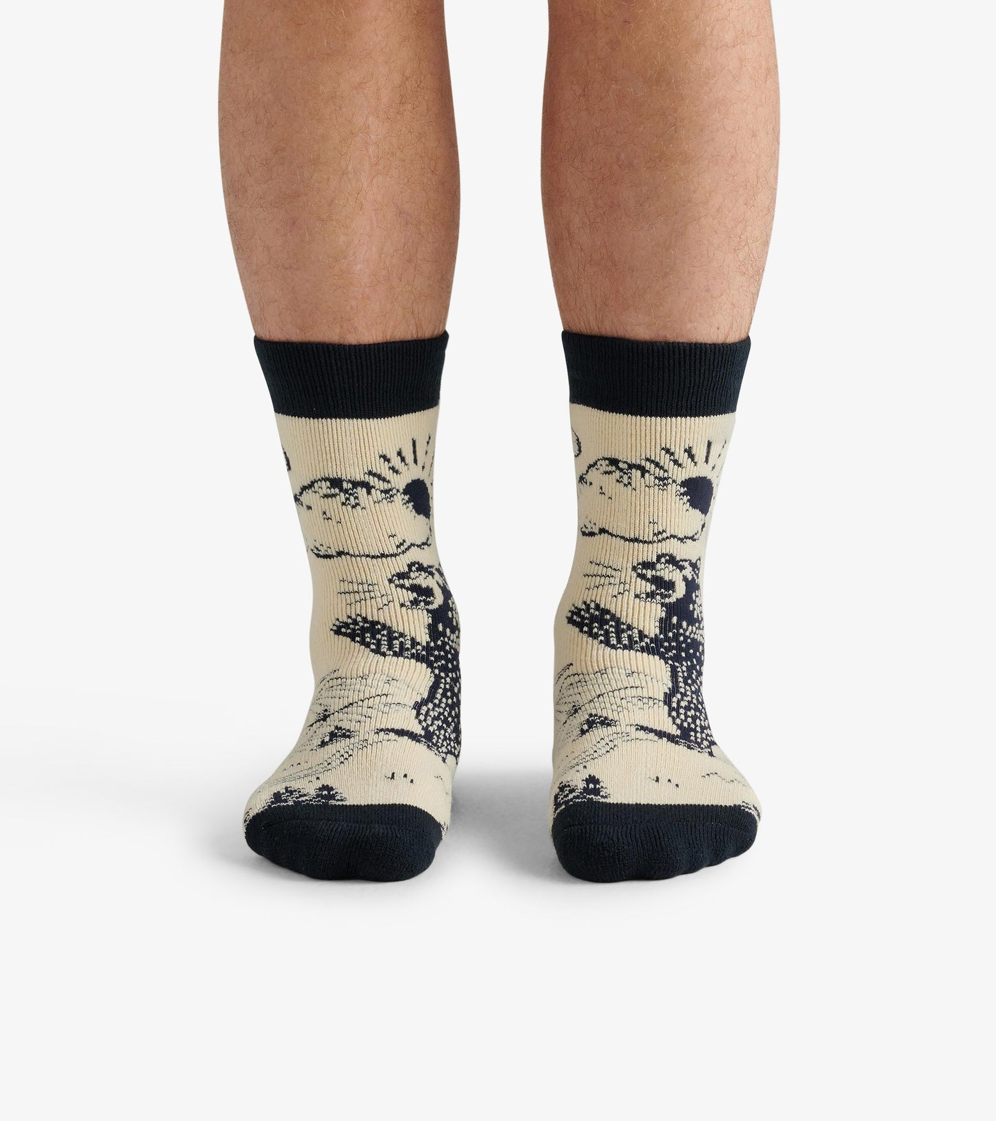 Beige cozy socks featuring a black bear design and dark ribbed cuffs, worn on feet.