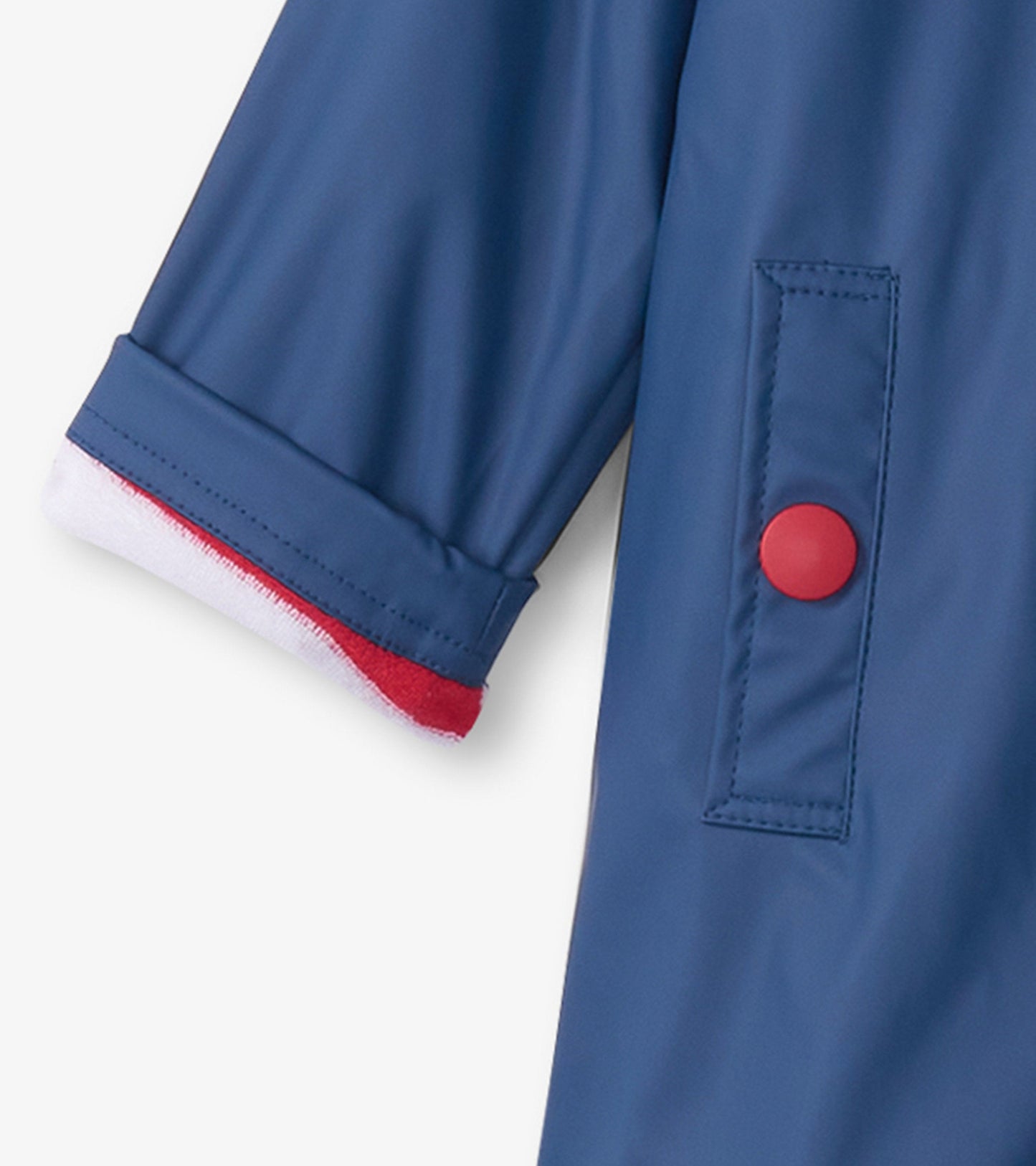 Navy raincoat with red button and contrasting red and white cuff detail, designed for kids.