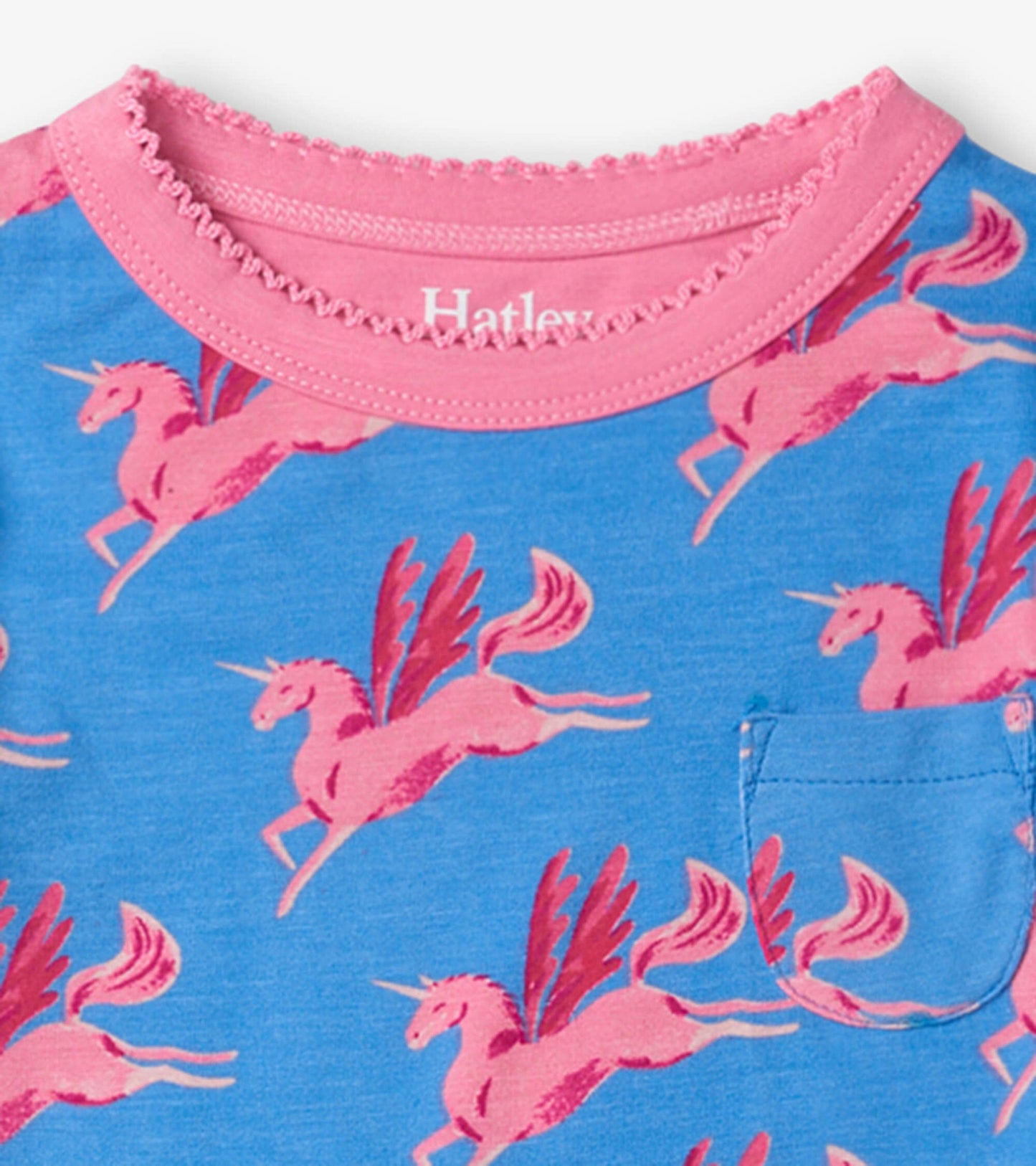Blue pajama top featuring pink flying unicorns and a small pocket, with a pink ruffled neckline.
