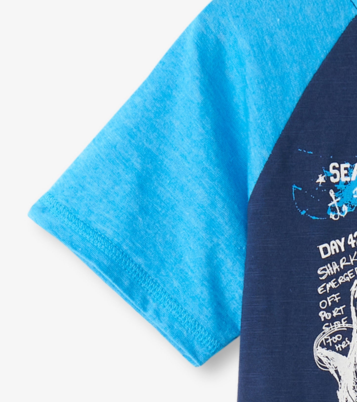 Blue and navy raglan t-shirt featuring a shark graphic and text design, suitable for boys.
