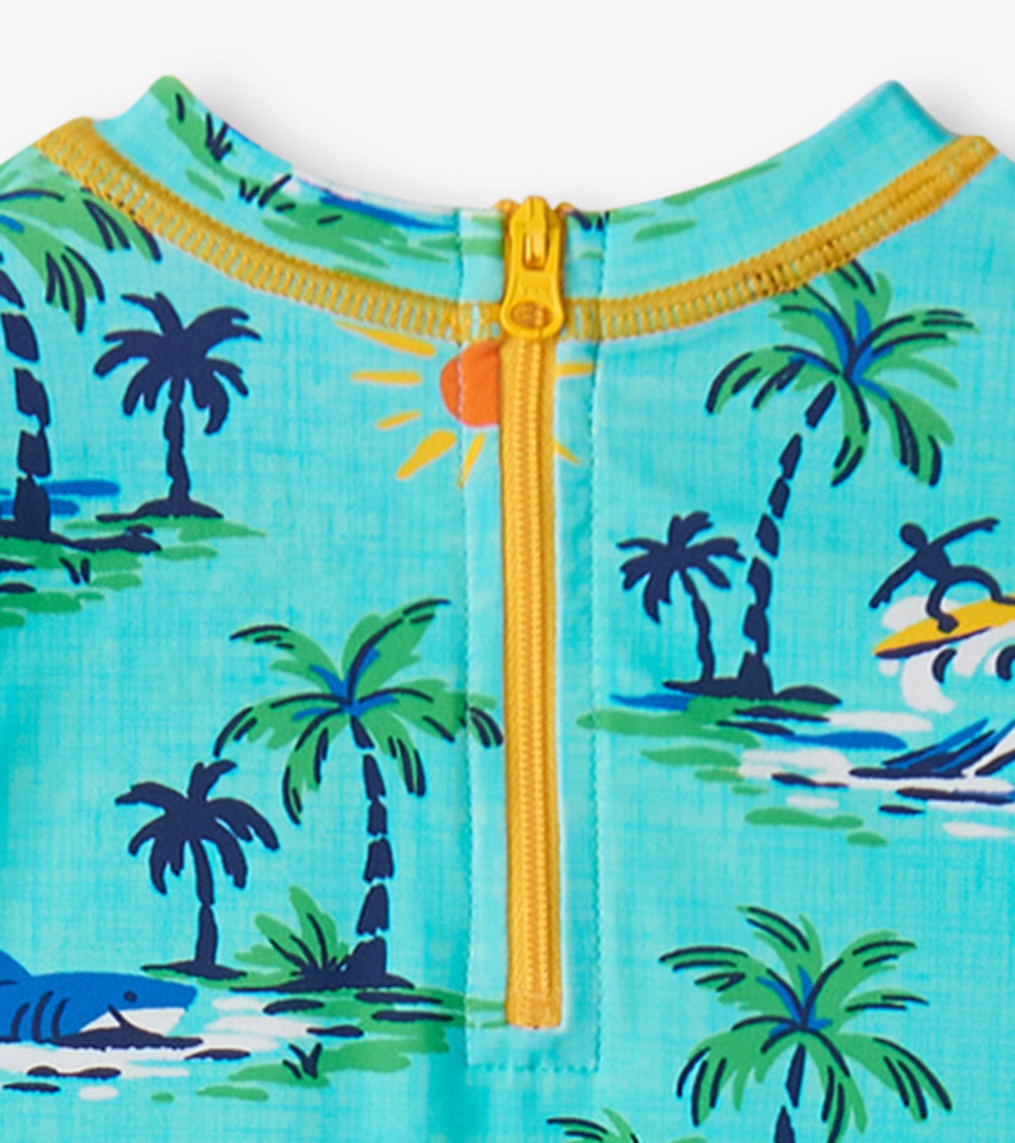 Light blue rashguard featuring a tropical print with palm trees and a shark, zip closure at the back.