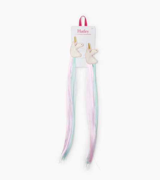 Two unicorn-shaped hair clips with pastel pink and blue faux hair extensions.