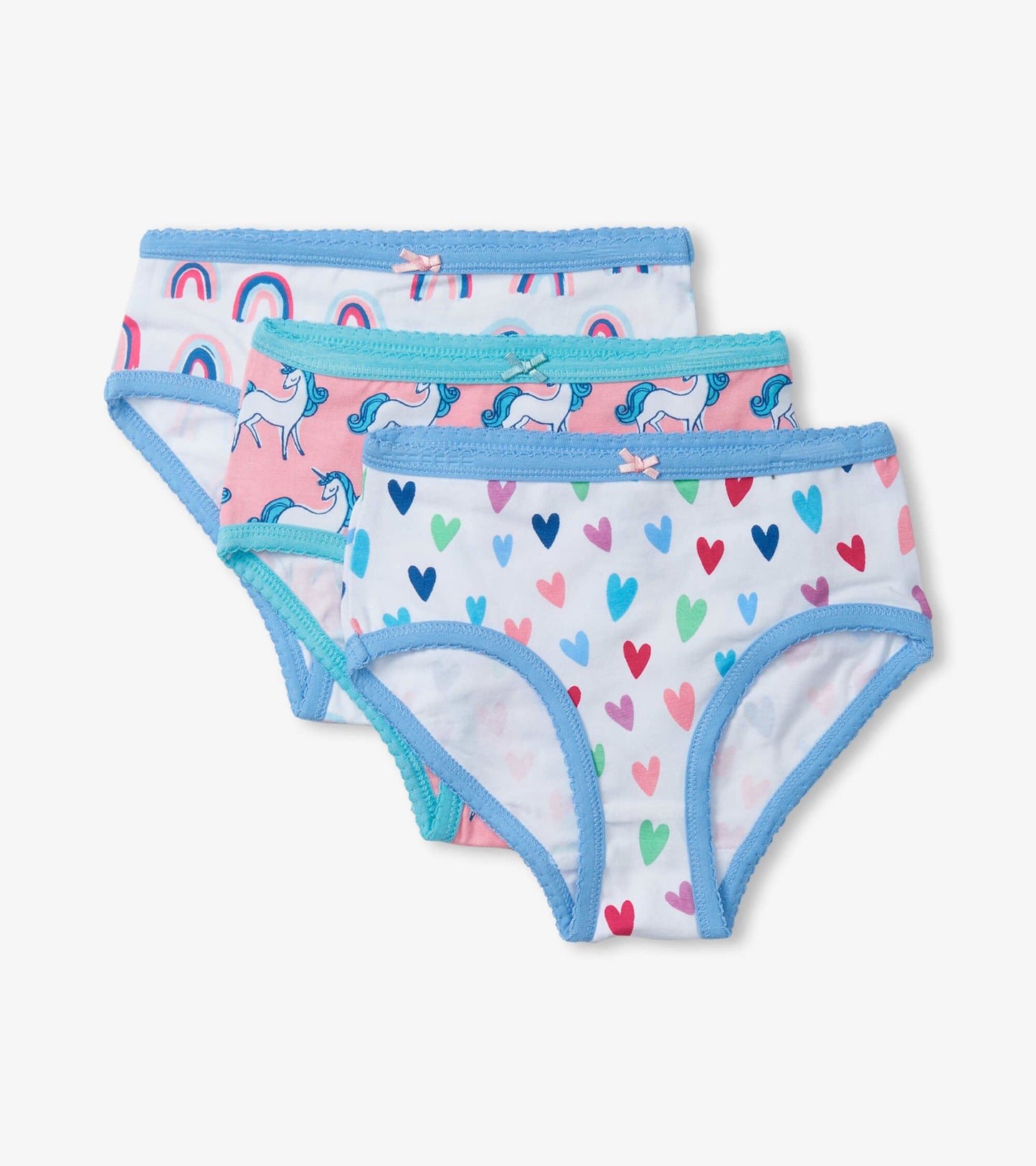 Three pairs of girls' brief underwear featuring unicorns, rainbows, and colorful hearts, with blue trim and bows.