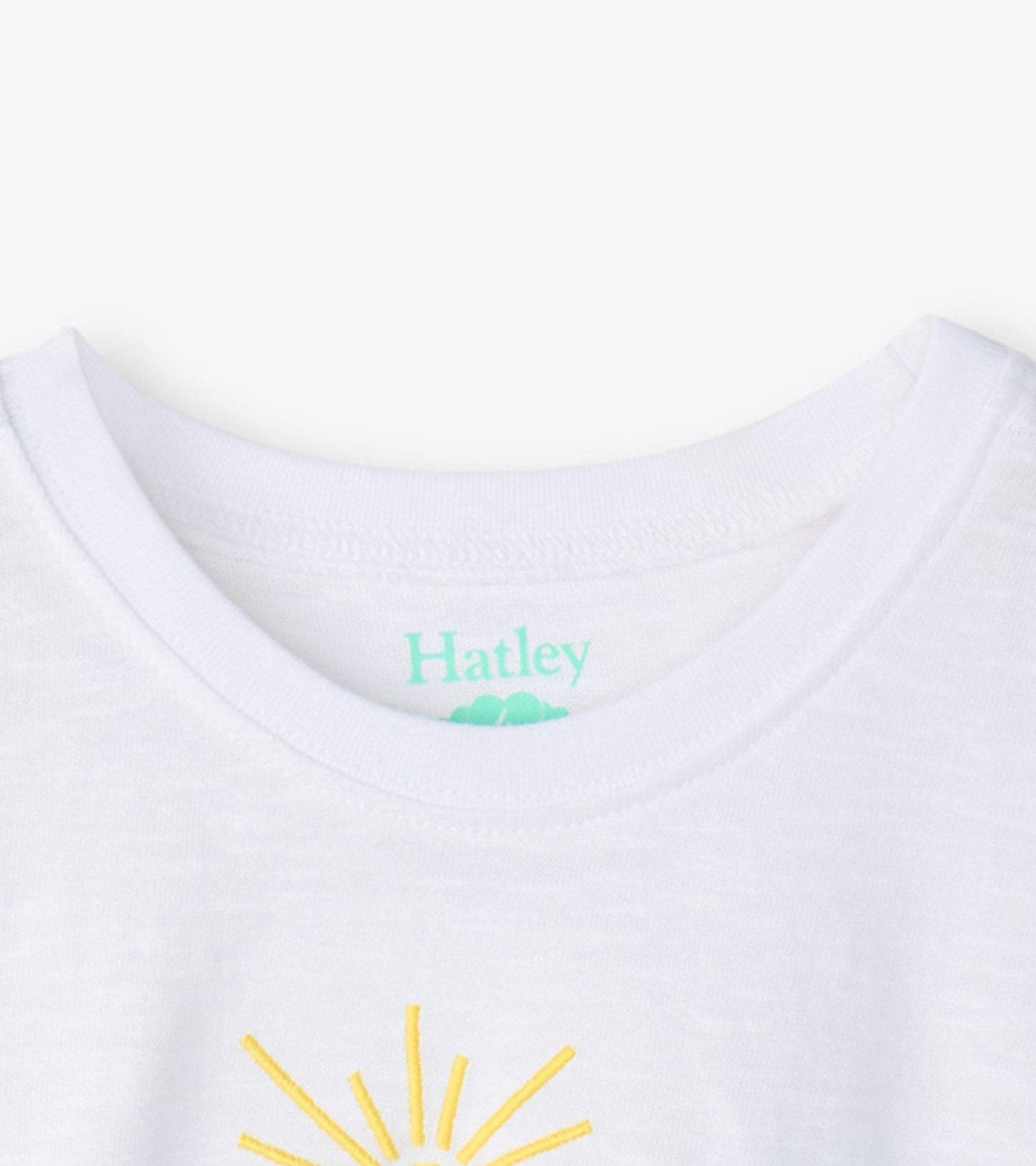 White boxy t-shirt featuring a yellow sun graphic, with a round neckline and short sleeves.