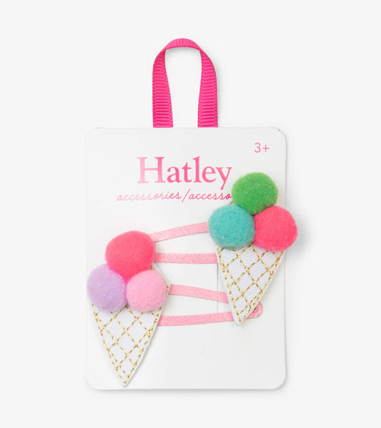Colorful pom pom cone snap clips with pink, green, and purple felt balls on a white cone design, attached to a pink ribbon.