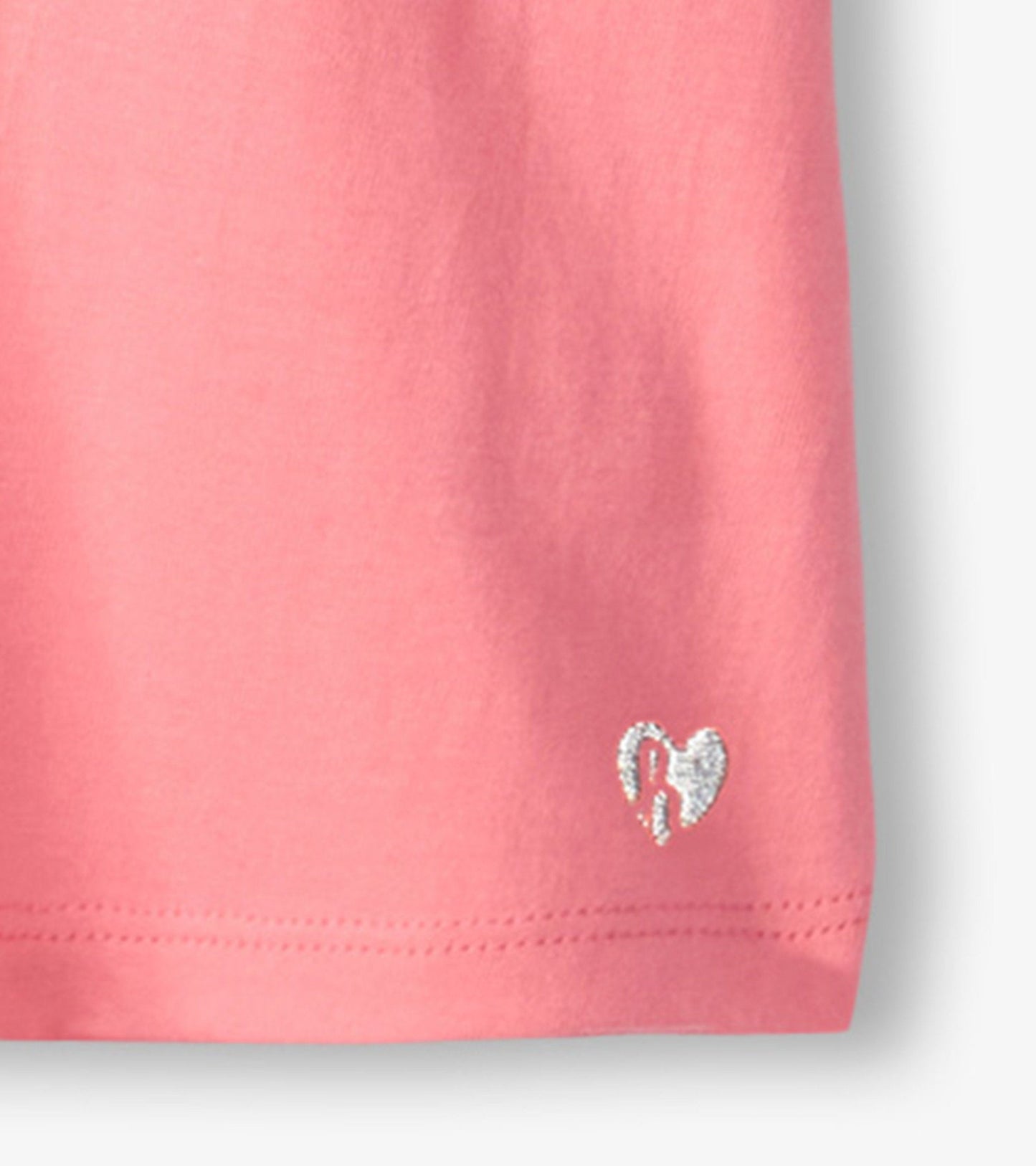 Pink short-sleeve tee with twisted sleeves and a small silver heart logo at the hem.