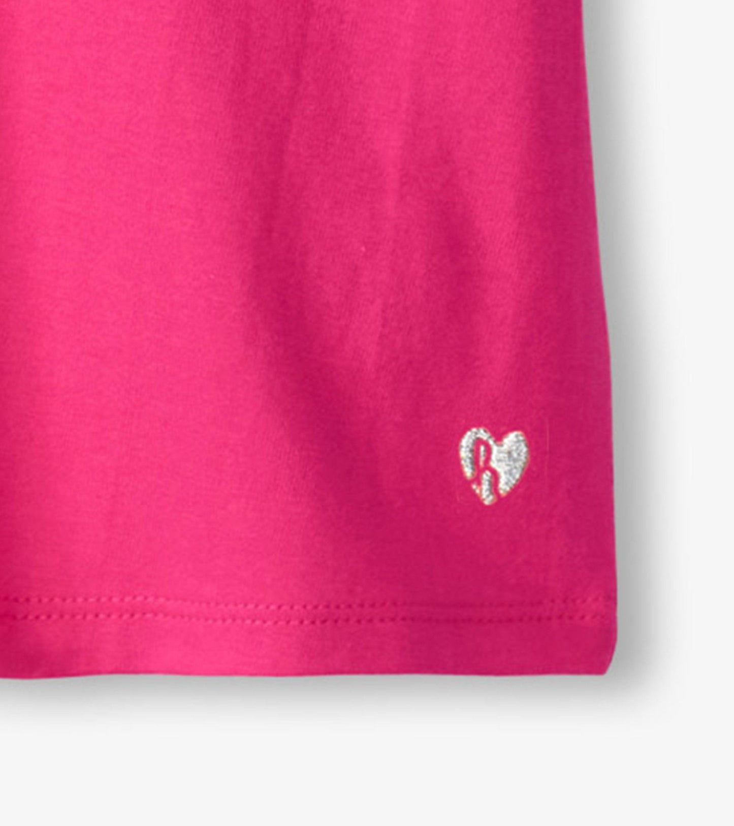 Bright pink short-sleeve tee with twisted sleeves and a small heart logo in silver on the front.