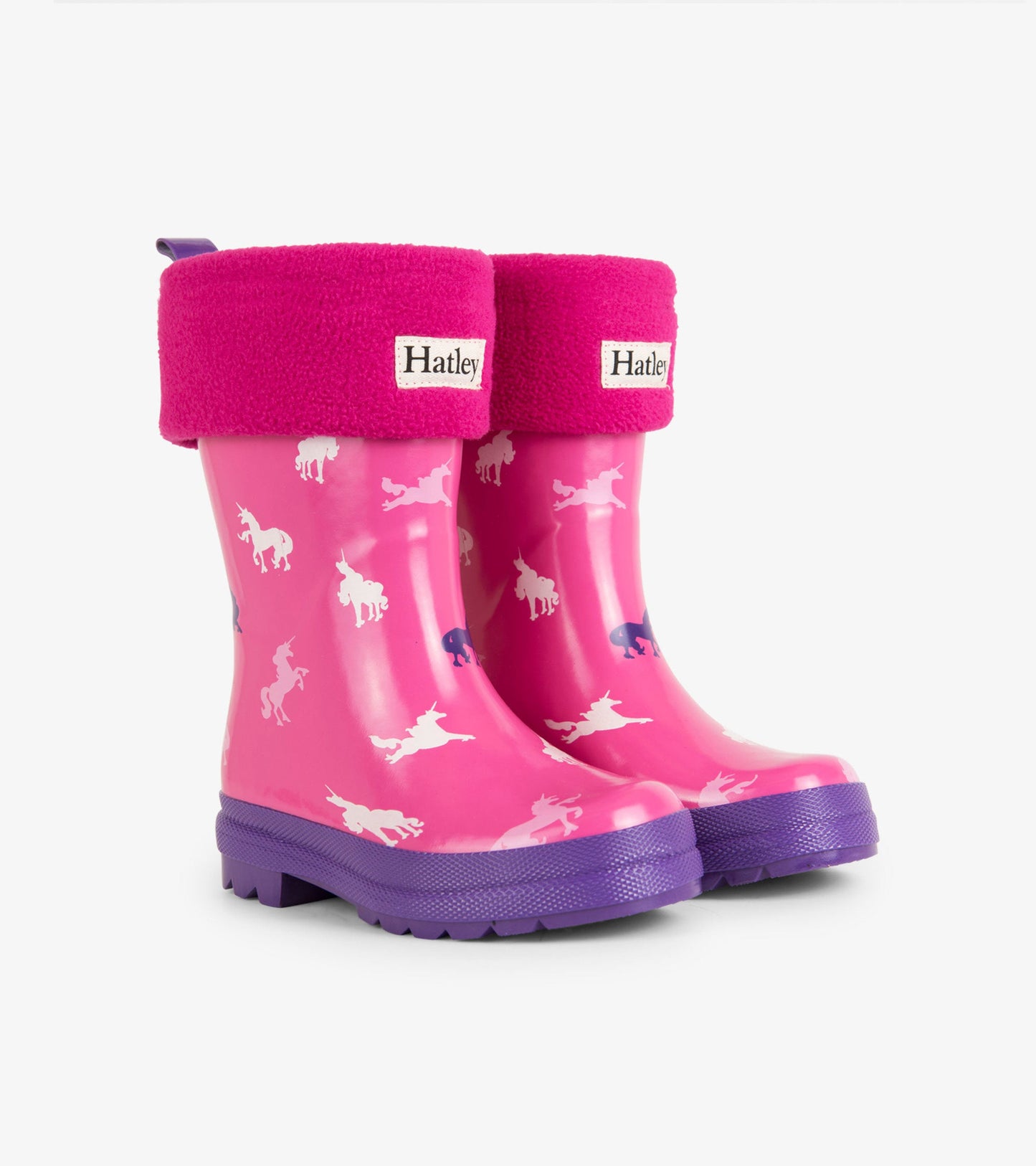 Magenta waterproof kids' boot liners with unicorn pattern and purple soles, featuring a soft pink fleece cuff.