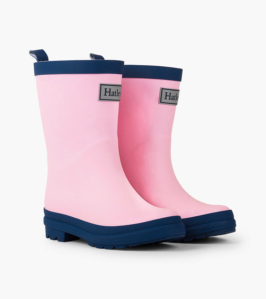 Pink and navy matte wellies with a textured sole and pull tabs, designed for kids.