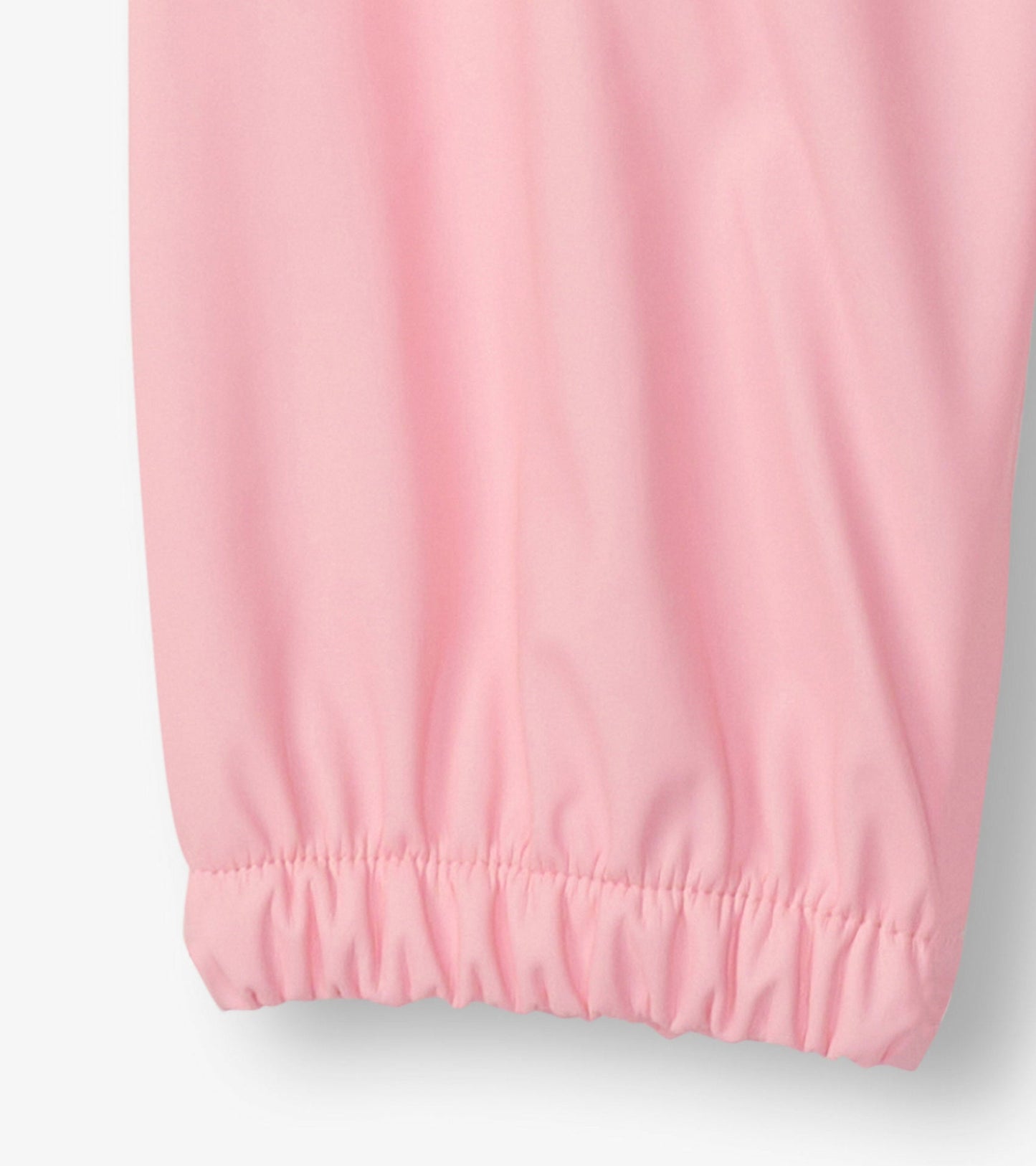 Light pink rain pants with elastic cuffs, designed for kids, made from waterproof material.