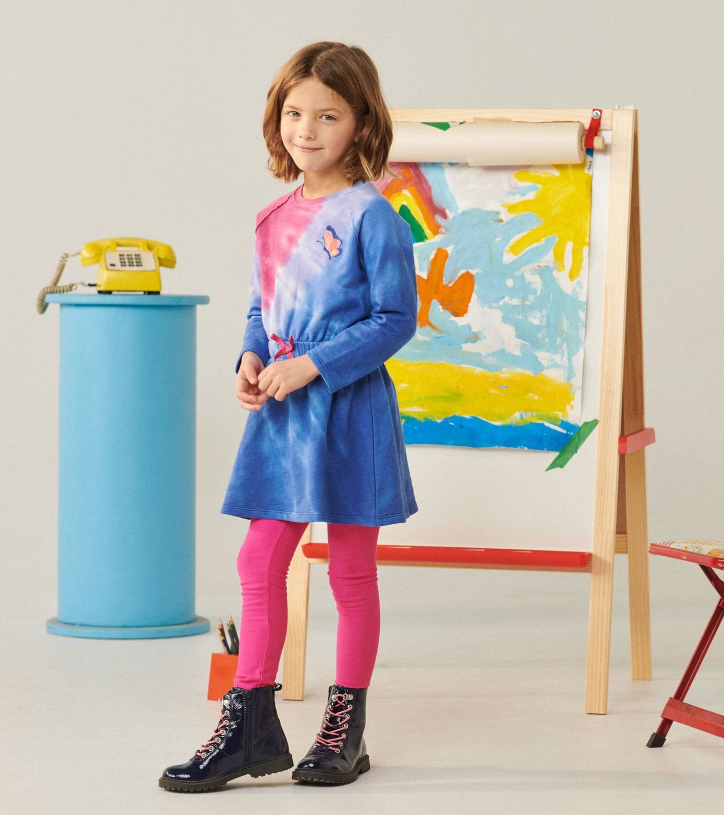 Cinched waist dress featuring a blue and pink tie-dye pattern, long sleeves, and a butterfly detail, styled with pink leggin…
