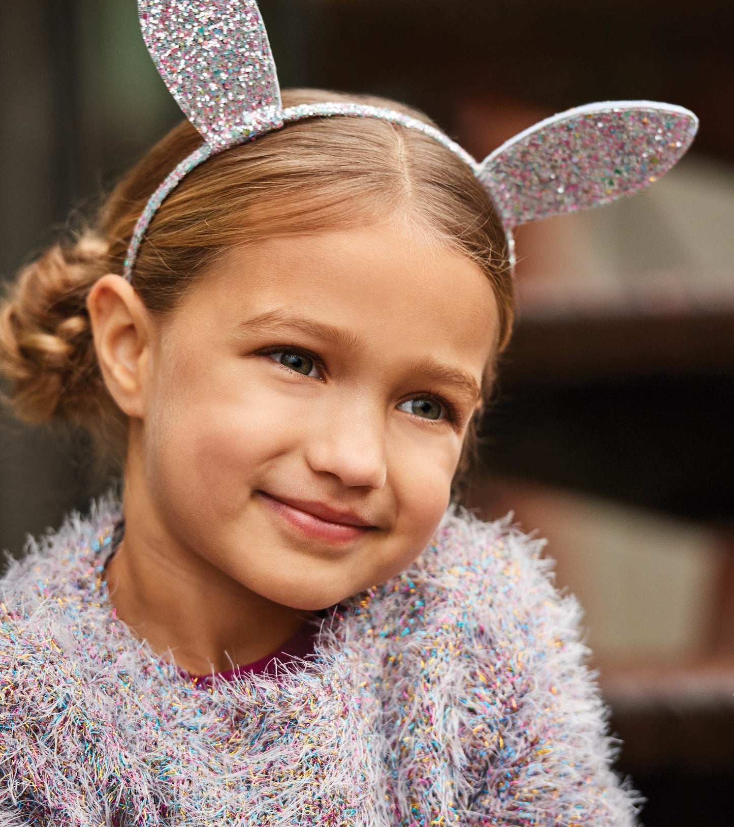 Glittery pastel bunny ears headband worn by a girl, featuring a sparkly design and soft fabric.