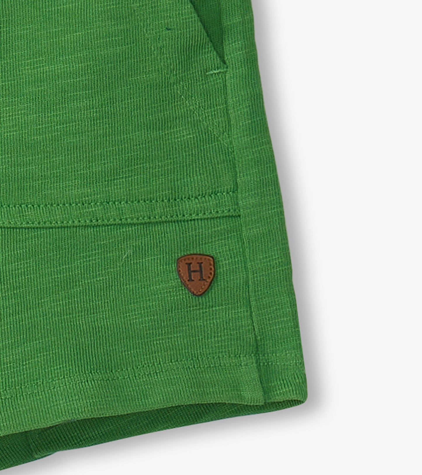 Green relaxed shorts with a textured fabric and a small brown logo patch, suitable for boys.